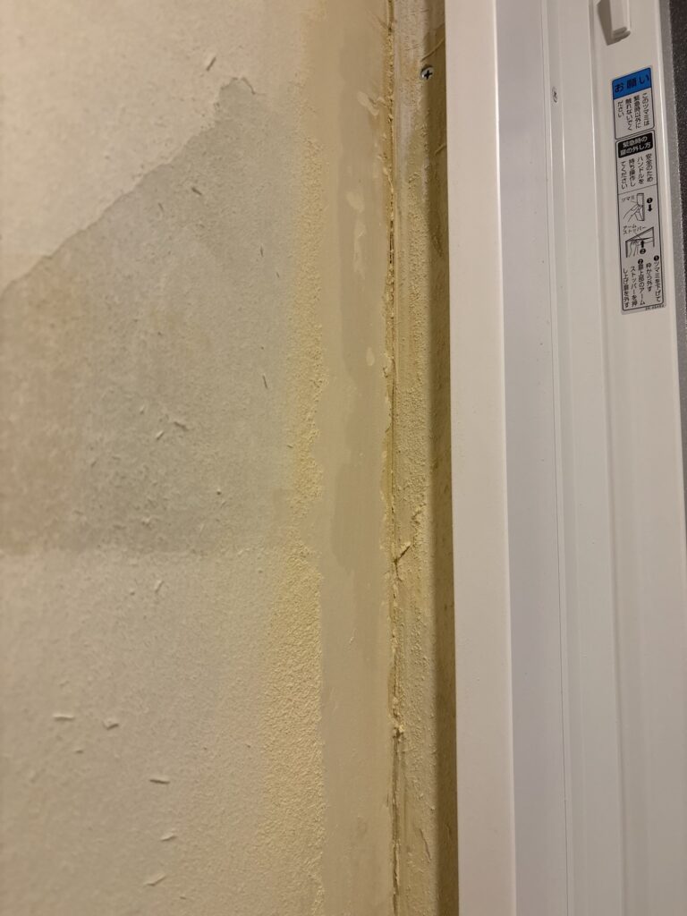 Wall filler sanded smooth with a sander to remove uneven areas before wallpaper installation.
