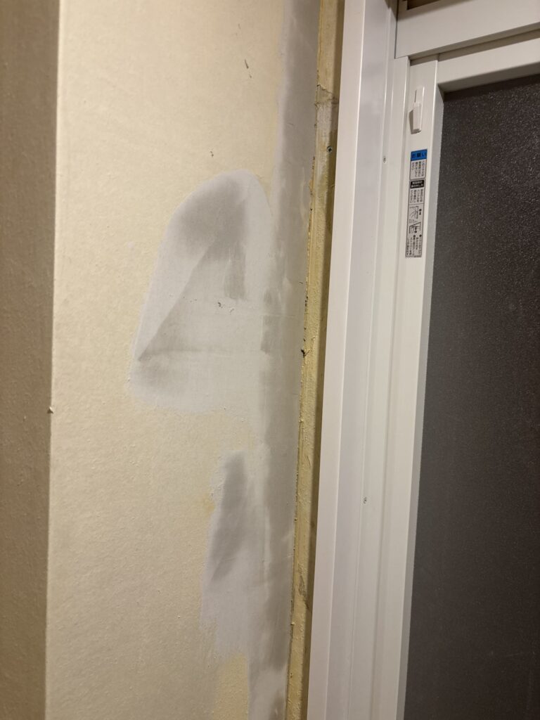 Base filler applied after sanding down an uneven section of wall.