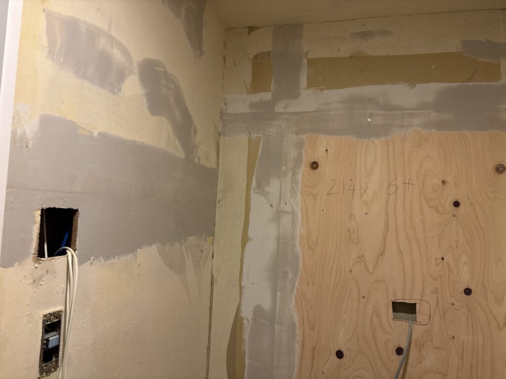 Base filler applied to a bathroom wall before finishing filler and wallpaper installation.
