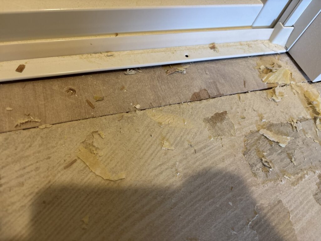 Height difference between new plywood and the existing floor near the bathroom entrance.