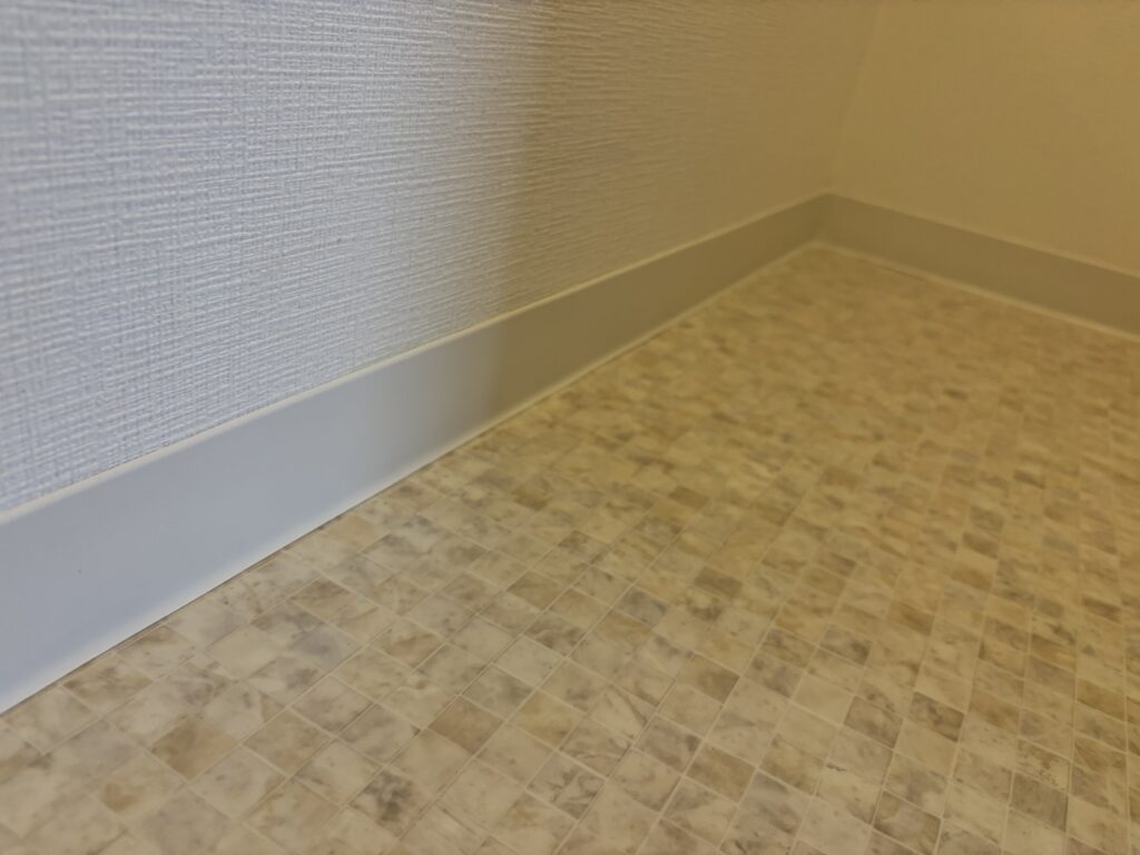Completed soft baseboard installation along the bathroom floor.