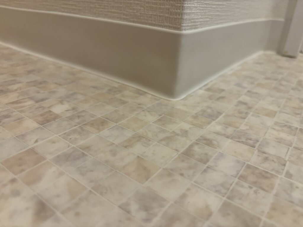 Soft baseboard wrapped around an outside corner in a bathroom.