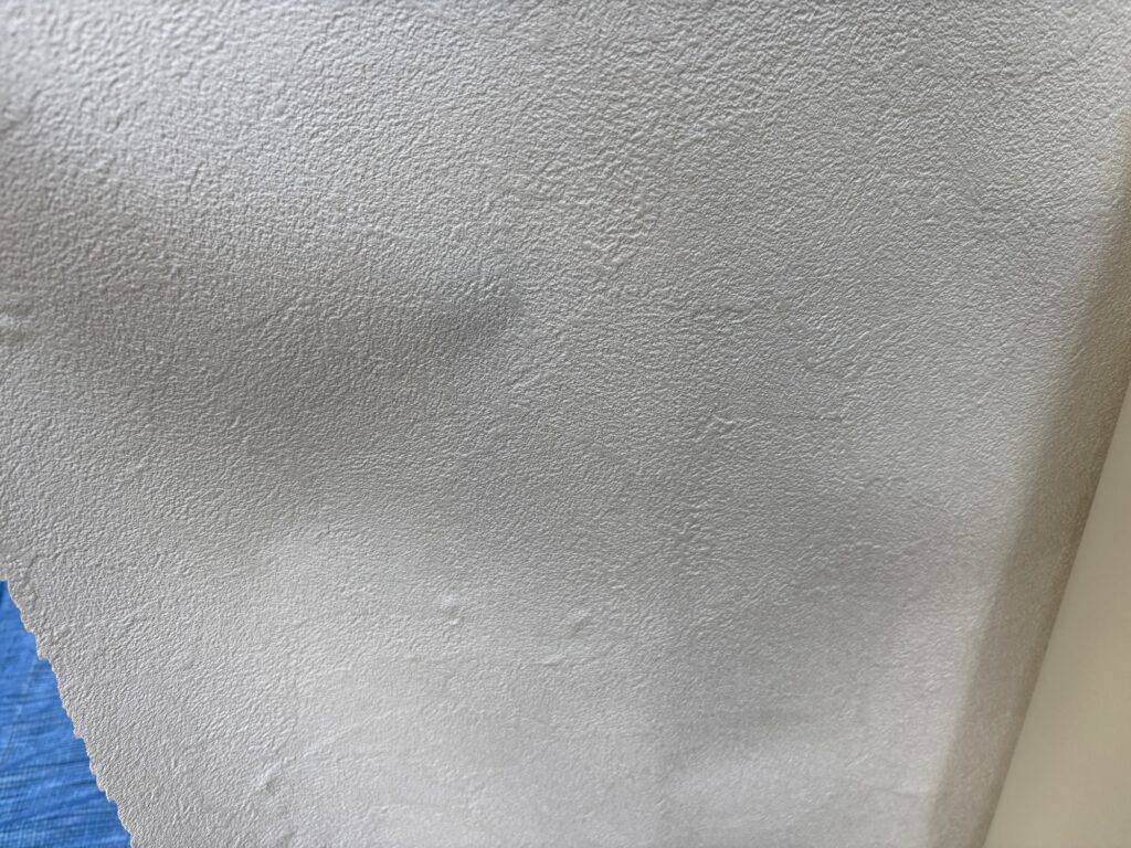 Thick white stone-pattern wallpaper material prepared for the toilet renovation