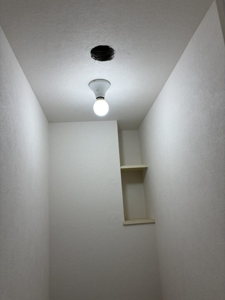 Completed wallpaper installation on the ceiling and walls of the renovated toilet