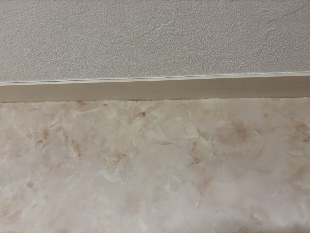 New vinyl flooring fitted neatly underneath the wooden baseboard