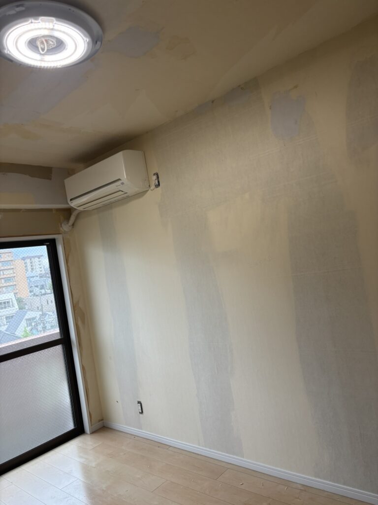 Room wall before partial wallpaper replacement in a condominium apartment.
