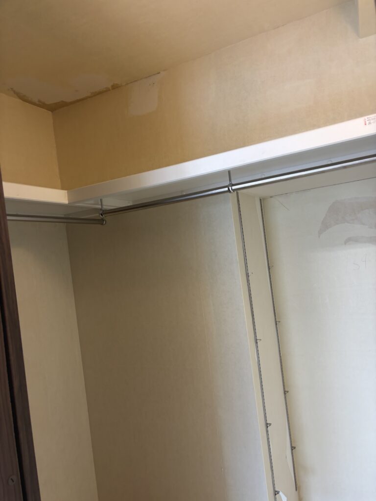 Interior of a walk-in closet before new wallpaper installation.