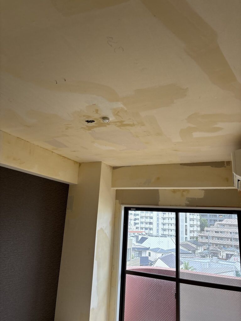 Fist-sized hole in the ceiling before wallpaper installation.