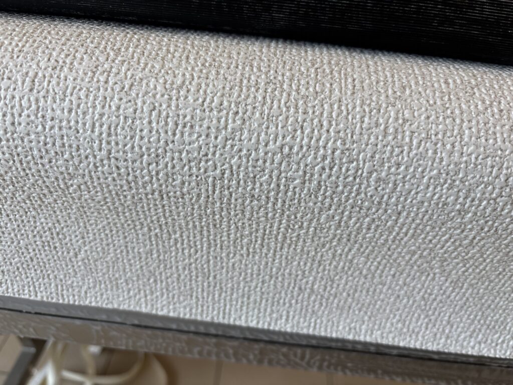 Thick embossed wallpaper material with a textured surface for an apartment renovation.