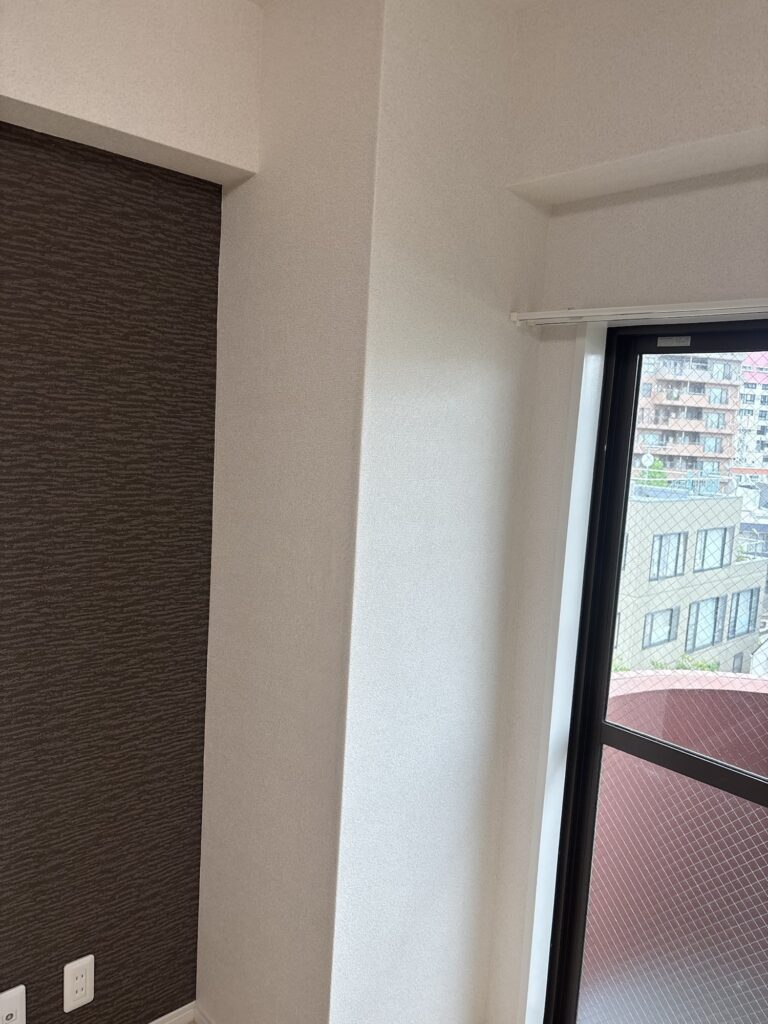 Completed wallpaper installation on a structural column inside a condominium room.