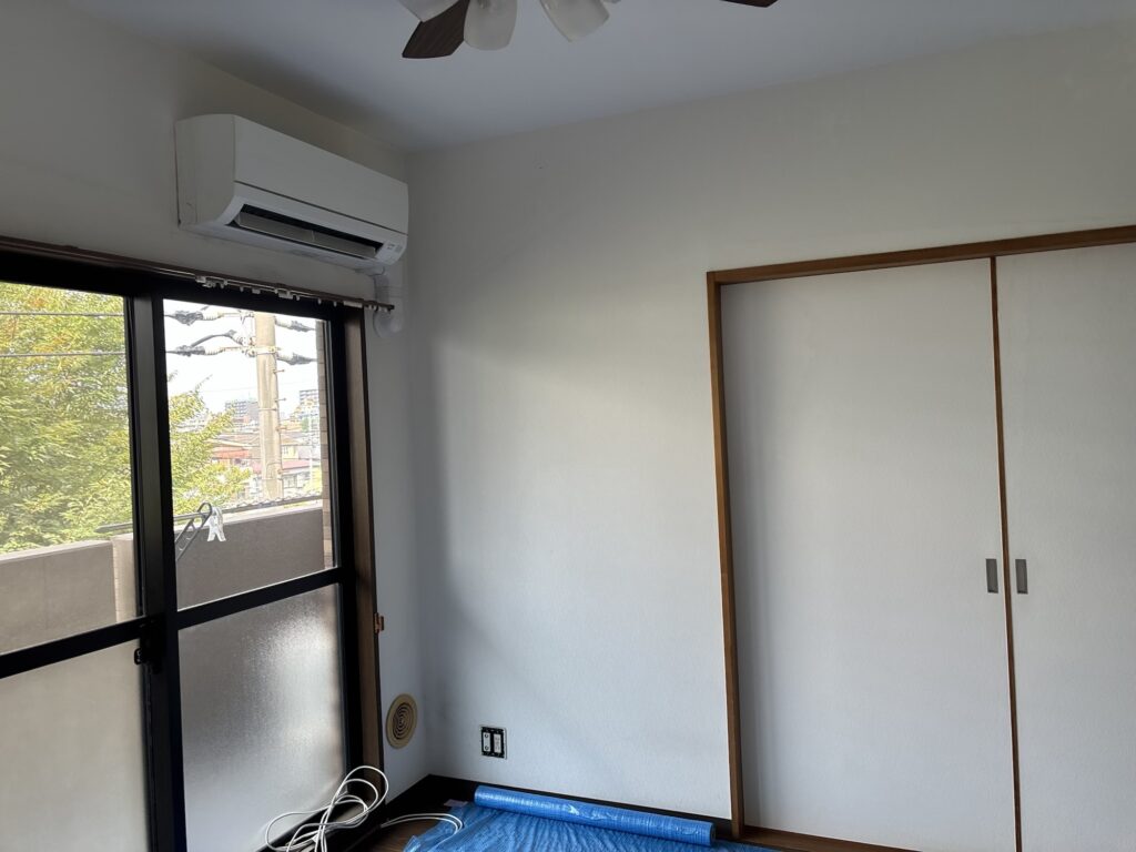 Completed white wallpaper installation in the living room of a Japanese condominium