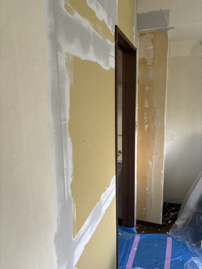 Wall with base coat joint compound applied to plasterboard joints