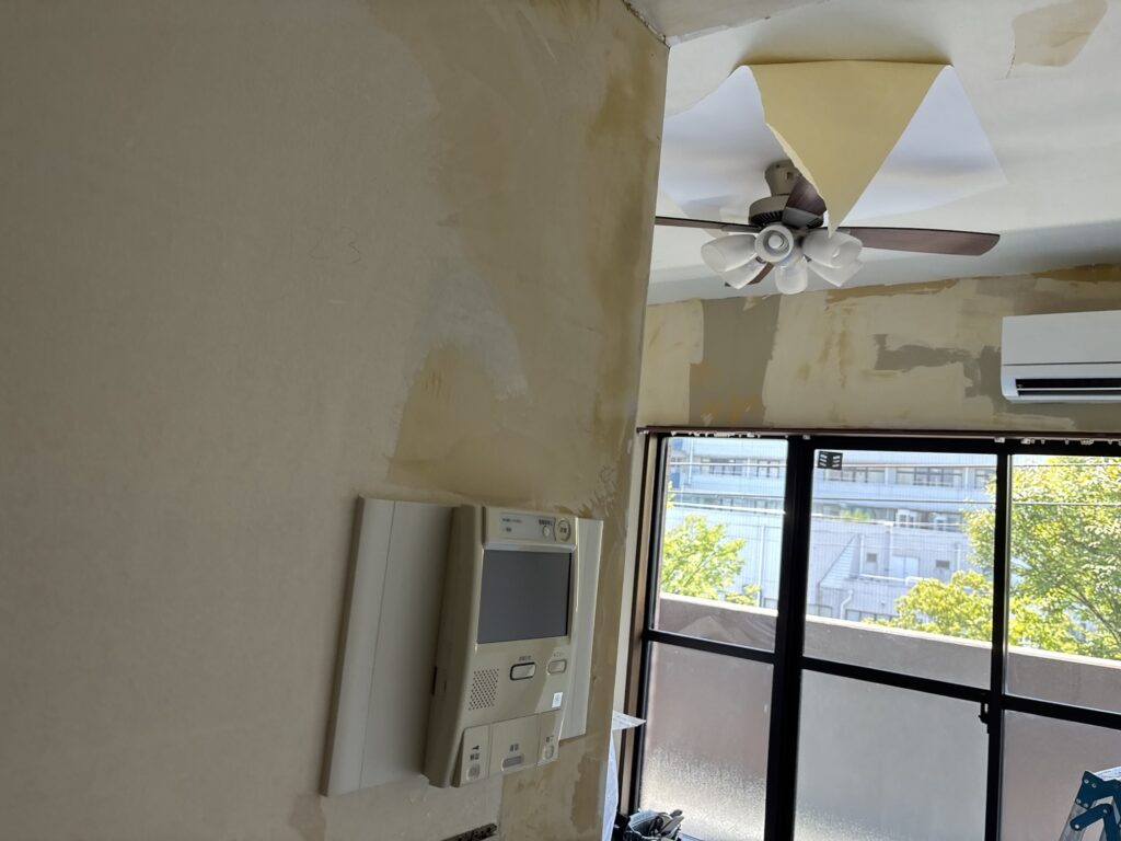 Finished joint compound around an intercom on a living room wall