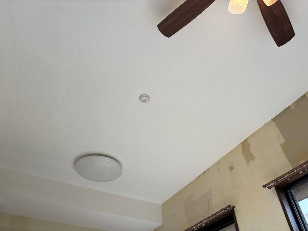 Completed white wallpaper installation on the ceiling and beam in a Japanese apartment