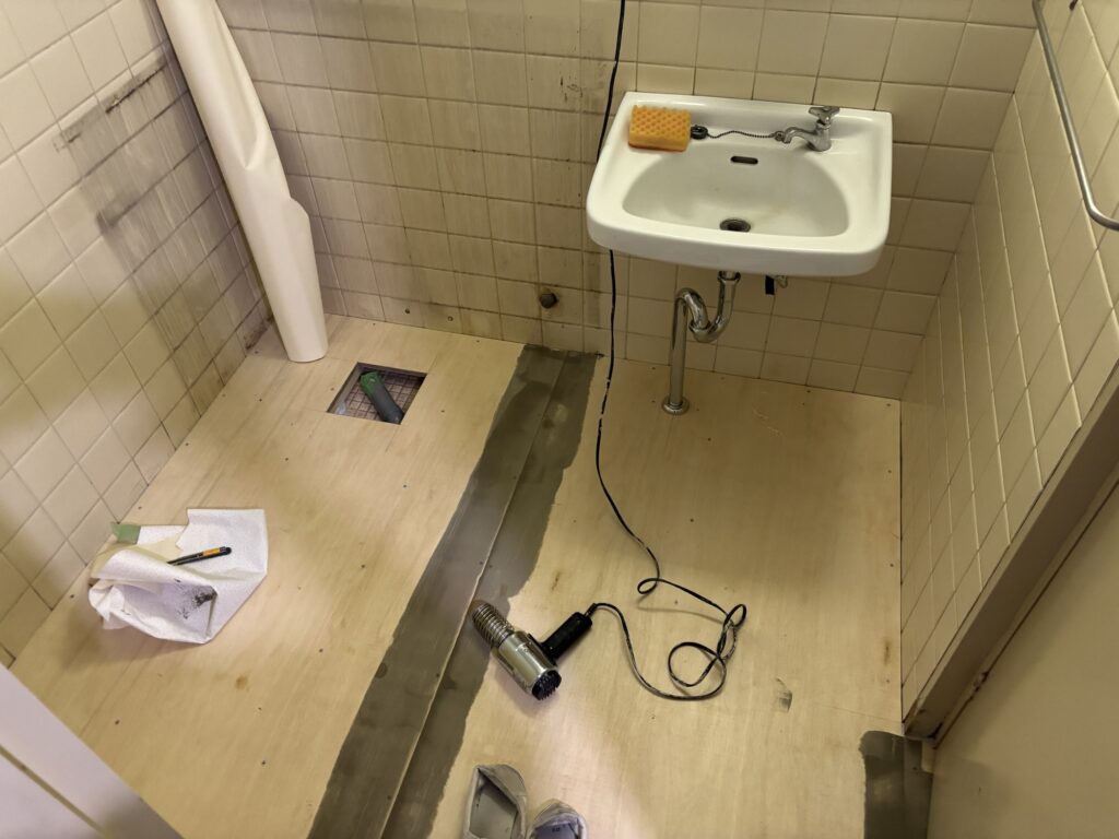 Heat gun being used to dry joint compound on a plywood subfloor