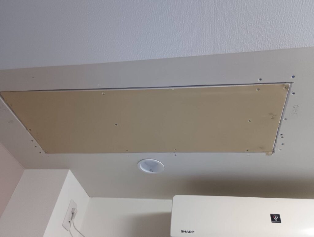 New gypsum board installed on part of a living room ceiling after plumbing repairs