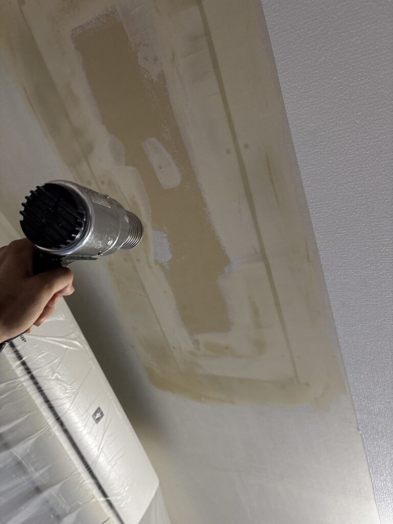 Using a heat gun to dry finishing joint compound before ceiling wallpaper installation