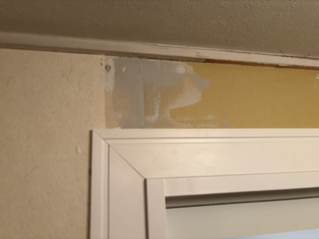 Base joint compound completed on repaired gypsum board beside the washing machine area