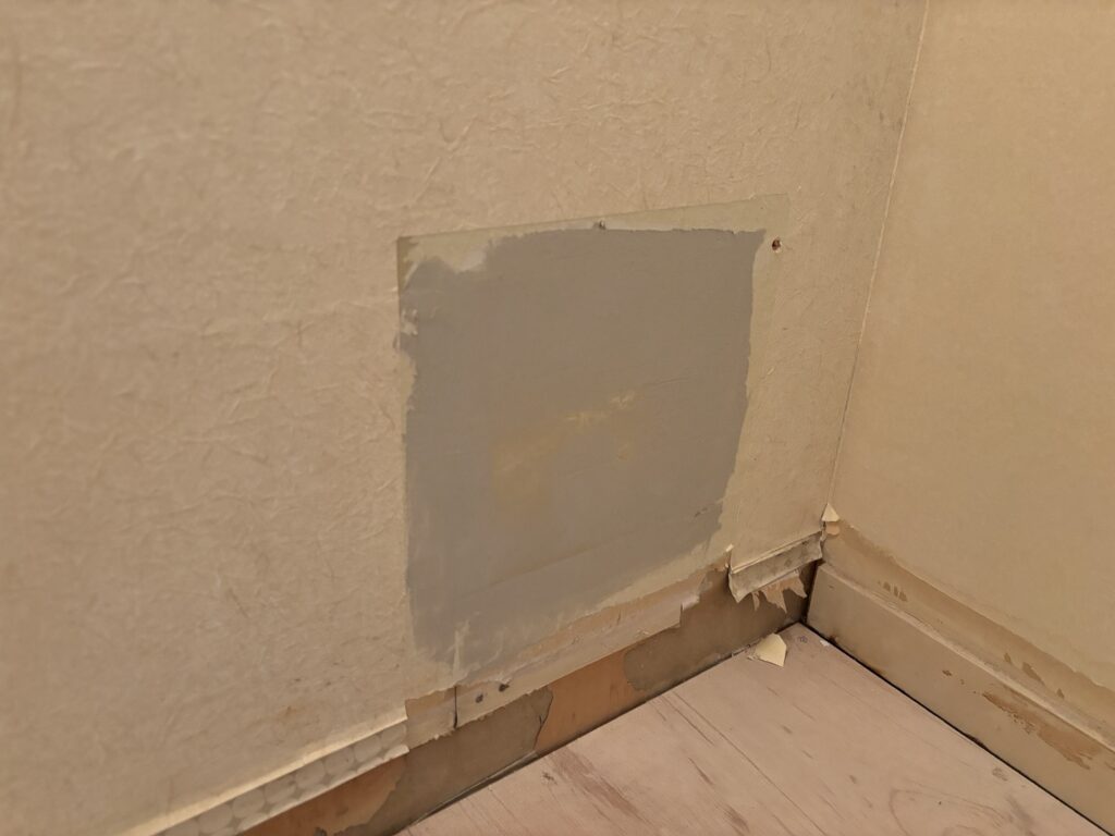Base joint compound being applied to new gypsum board beside the washing machine area