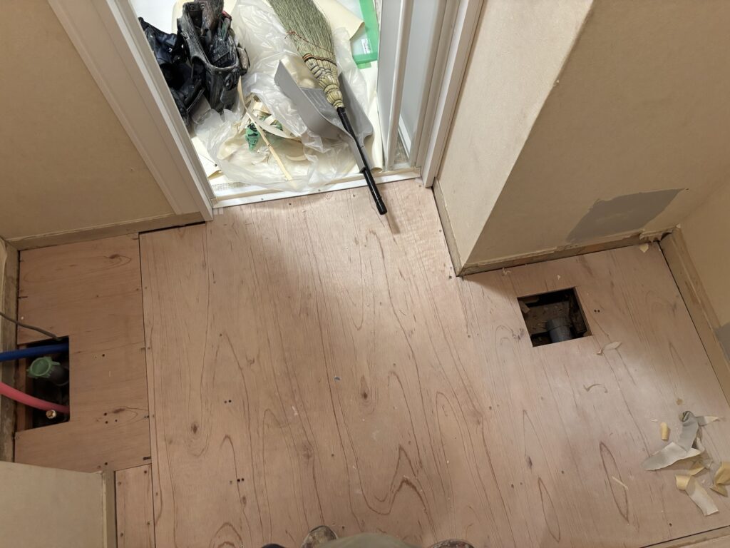 Washroom plywood subfloor before cushion flooring replacement