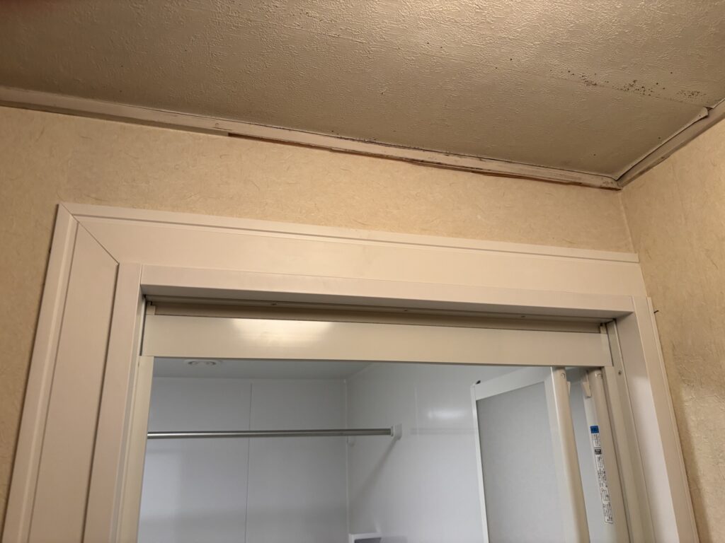 Close-up of a completed wallpaper patch repair beside the washing machine area