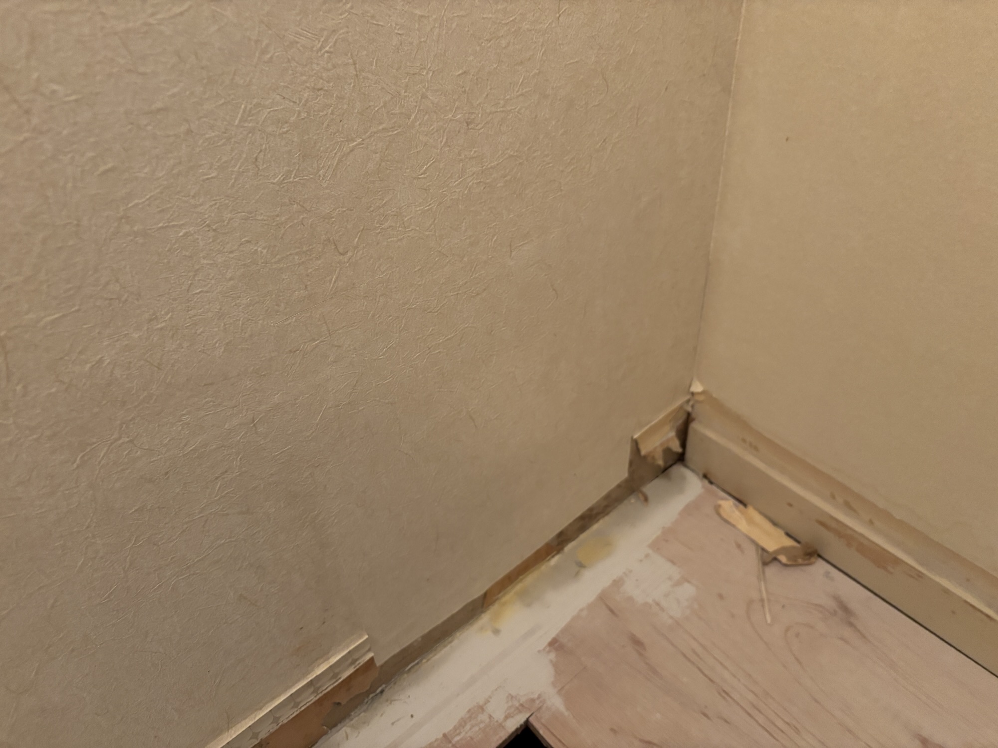 Completed partial wallpaper repair beside the washing machine area in a Japanese apartment