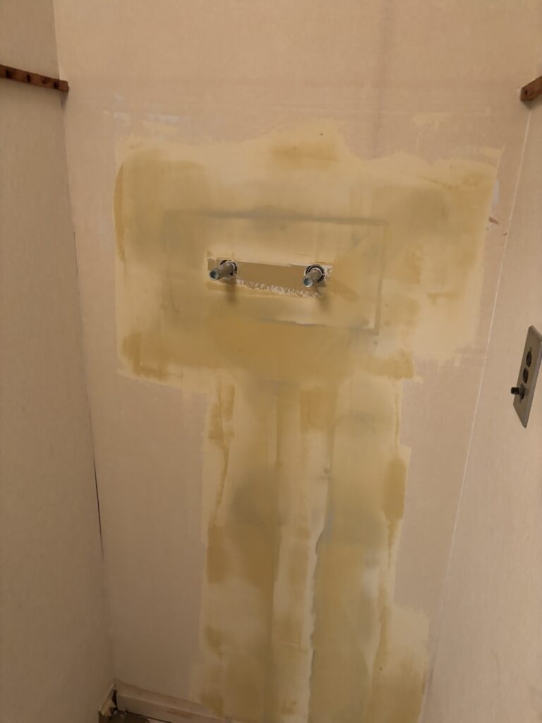 Finishing joint compound applied to smooth a repaired wall before wallpaper installation