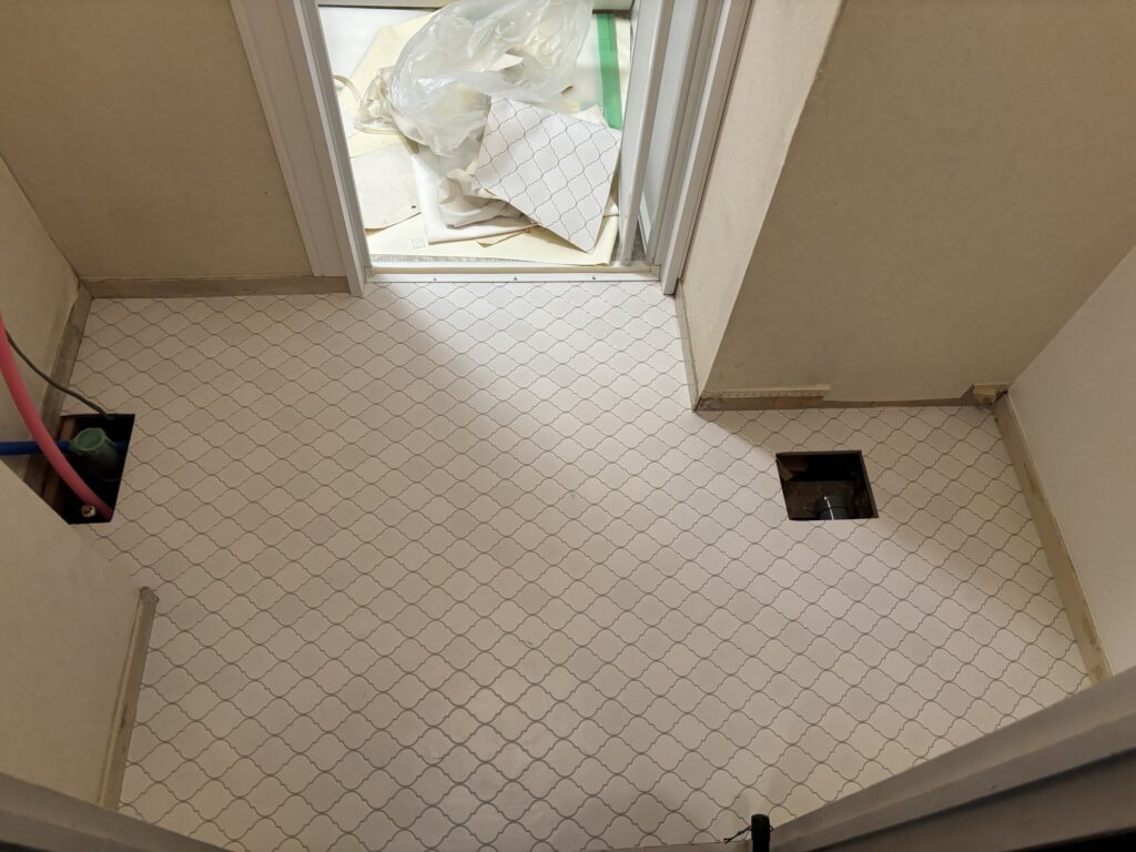 Completed patterned cushion flooring installation in a Japanese apartment washroom