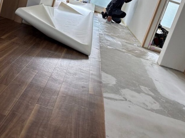 Adhesive being applied to the floor before cushion flooring installation.