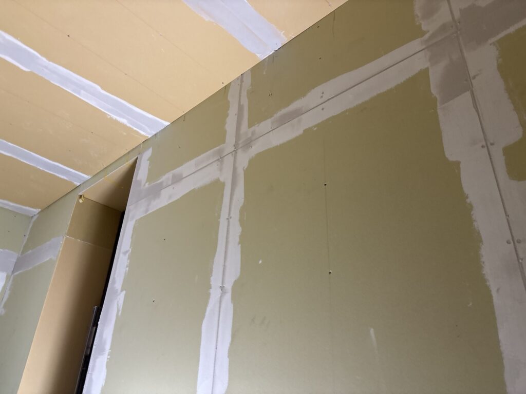 First coat of joint compound applied to the seams of newly installed gypsum board.