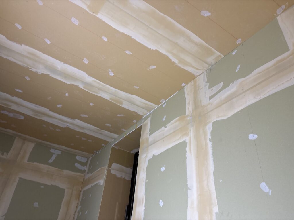 Ceiling surface with finishing joint compound completed before wallpaper installation.