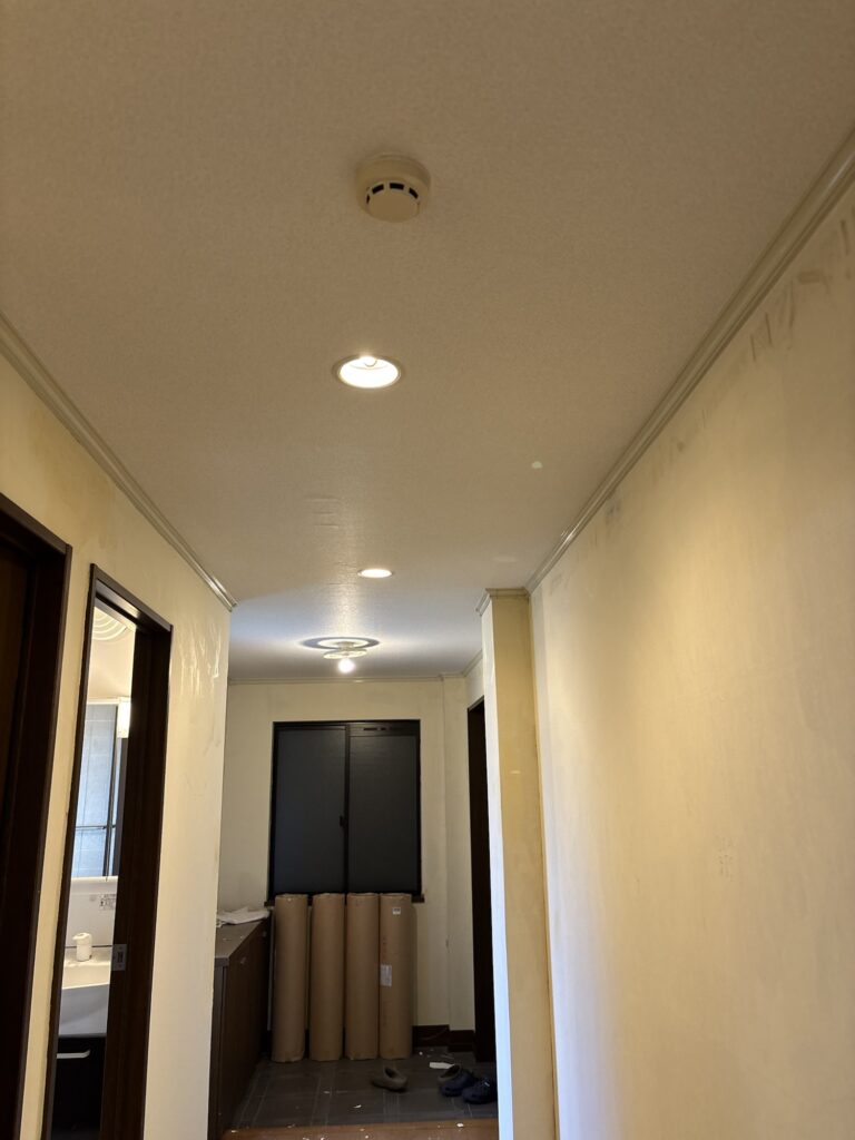 Completed hallway ceiling with new wallpaper in a condominium apartment