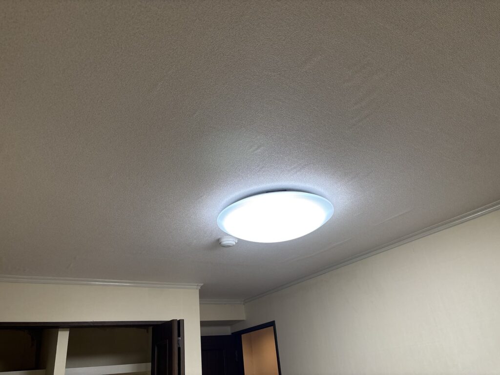 Completed bedroom ceiling with new wallpaper in a 2LDK apartment