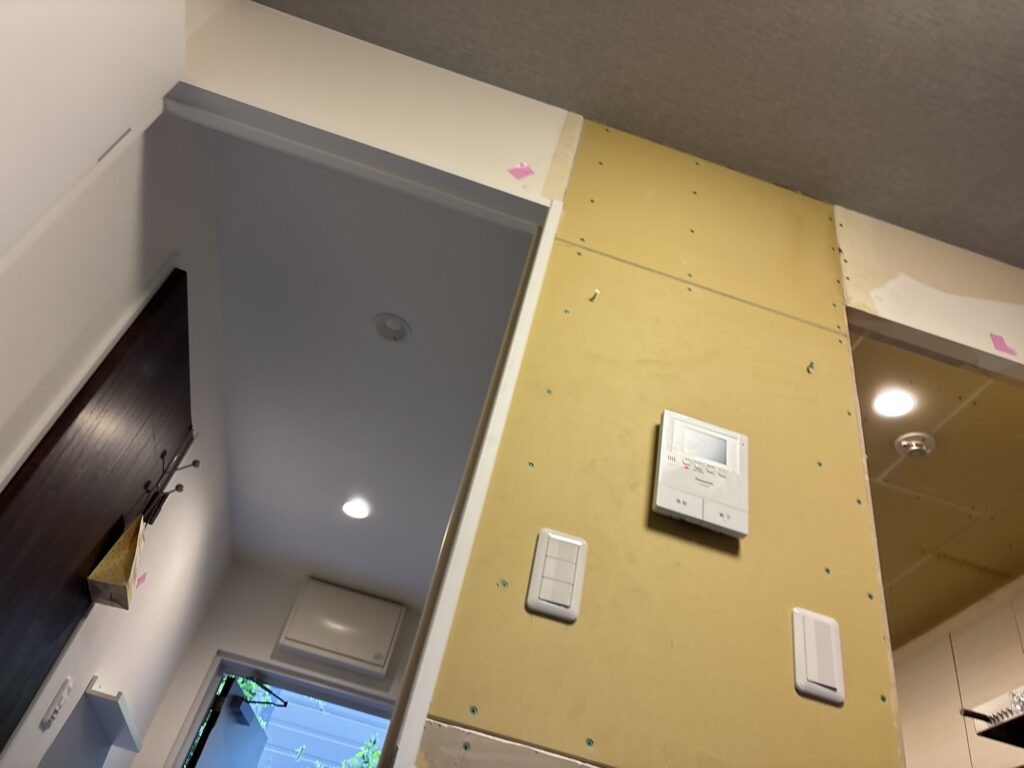 Close-up view of newly installed gypsum board on the kitchen ceiling, showing the repaired area before wallpaper installation.