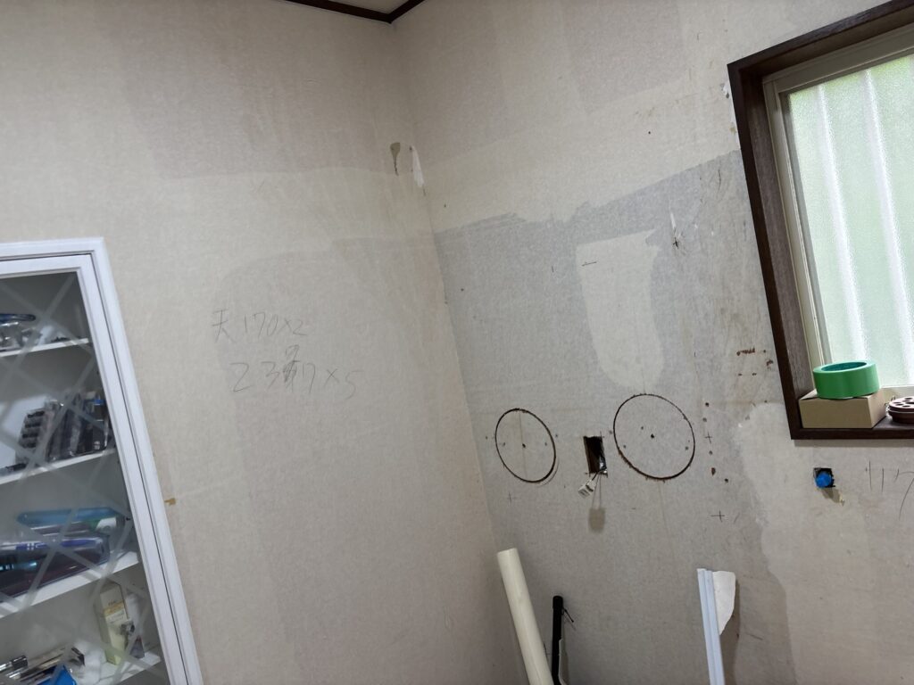 Repaired section of the washroom wall before wallpaper installation.