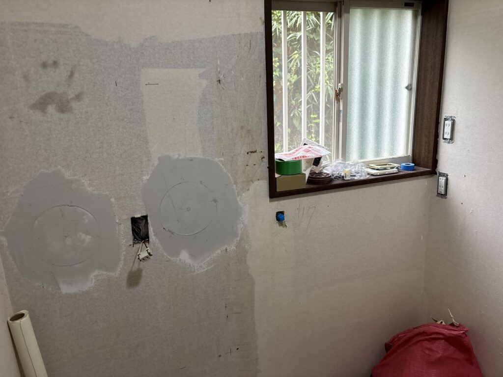 Repaired wall section covered with the first coat of joint compound.
