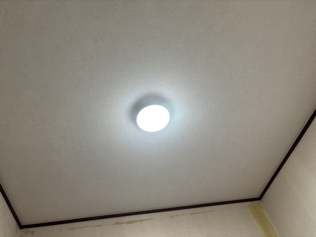Completed wallpaper installation on the bathroom ceiling.
