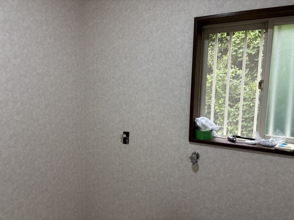 Close-up view of newly installed wallpaper on a washroom wall.