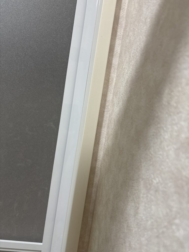 Wallpaper wrapped into the narrow space around the bathroom door frame.