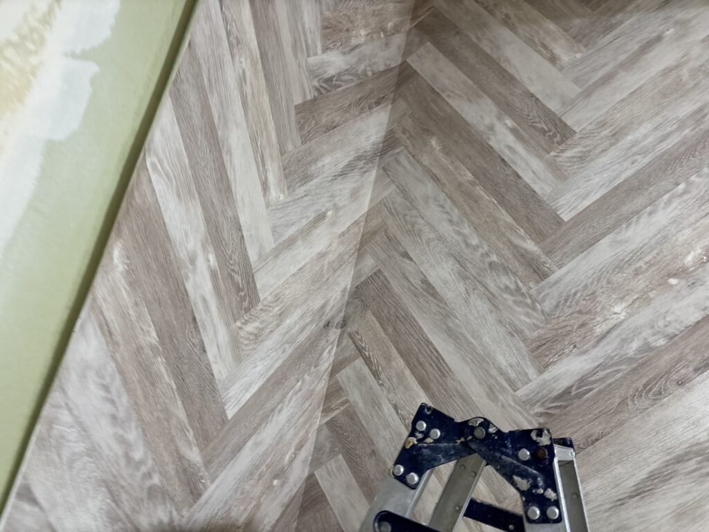Wallpaper wrapped around an inside corner of a hotel room wall.