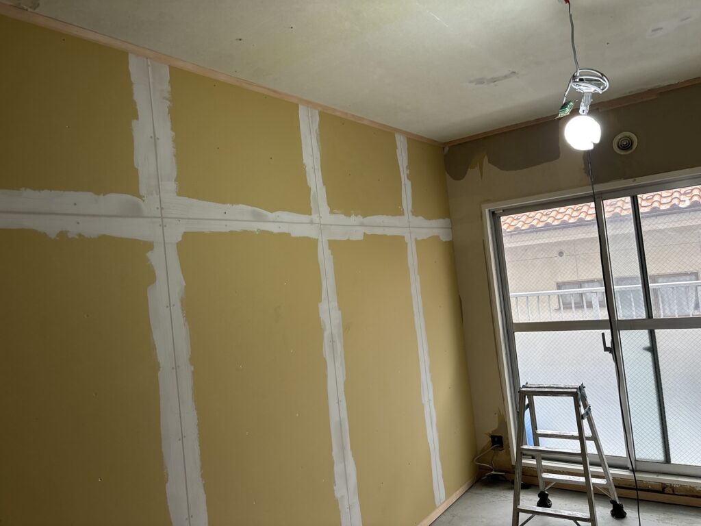 Base-coat joint compound applied to a Japanese-style room wall before wallpaper installation.