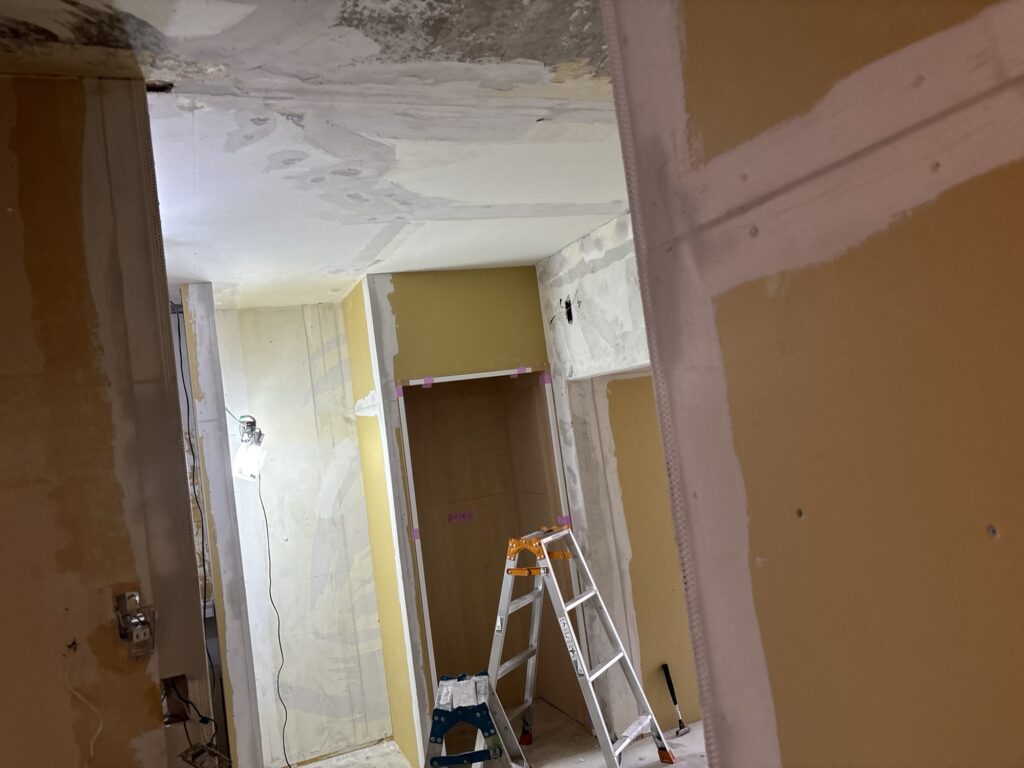 Base-coat joint compound applied to a wall before wallpaper installation.