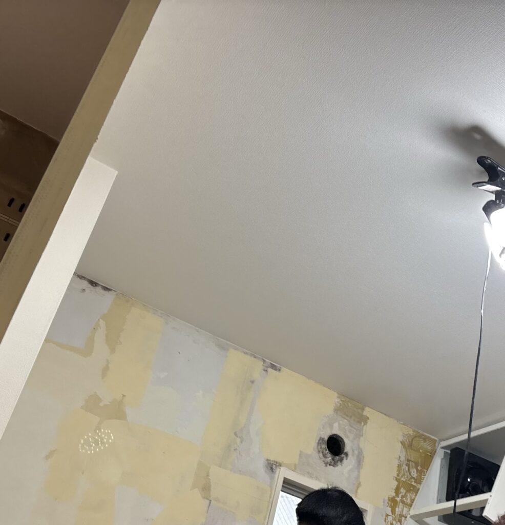 Completed white wallpaper installation on the living and kitchen ceiling.