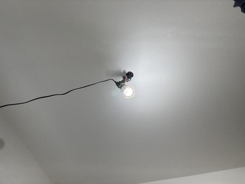 Finished wallpaper installation on the ceiling of a renovated room.