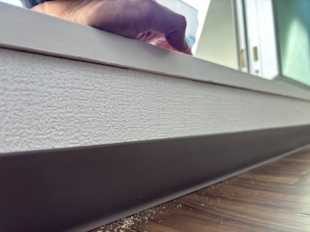 Finished soft baseboards installed along the walls of the renovated room.