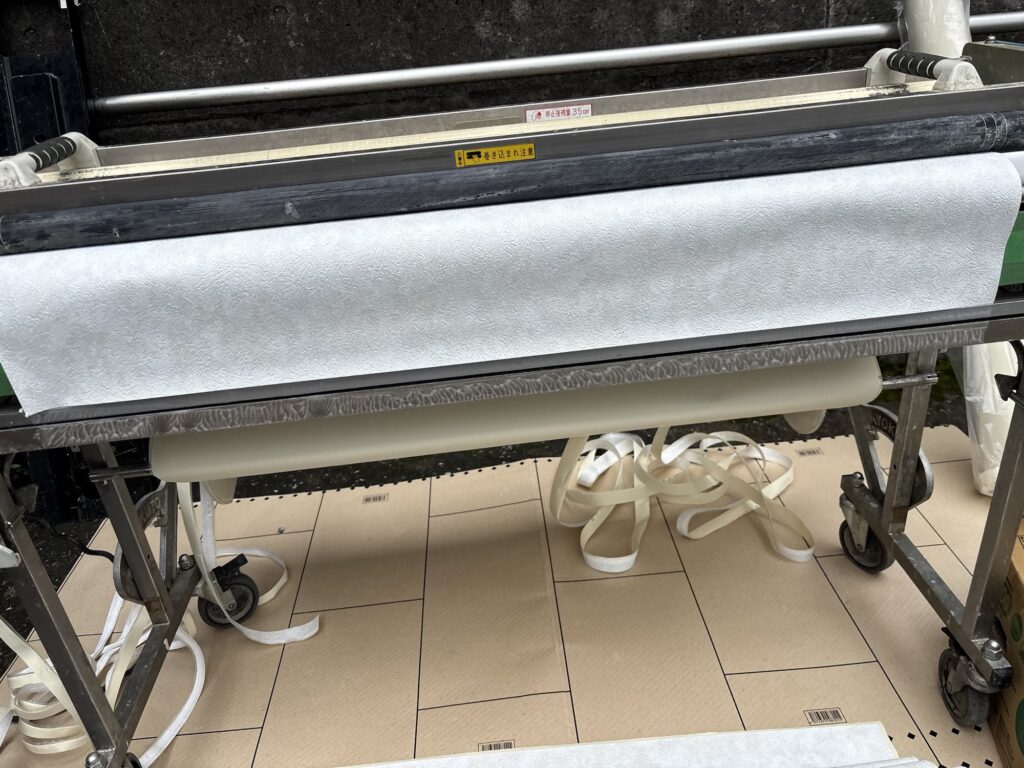 Wall wallpaper being prepared with a wallpaper pasting machine