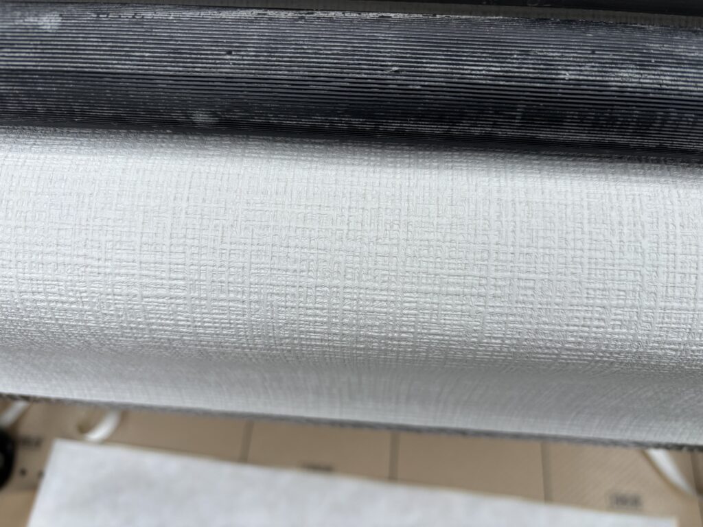 White grid-patterned wallpaper material prepared for the washroom ceiling
