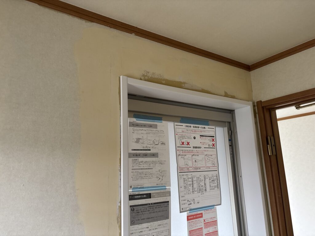Finishing filler applied around the bathroom door frame before wallpaper installation