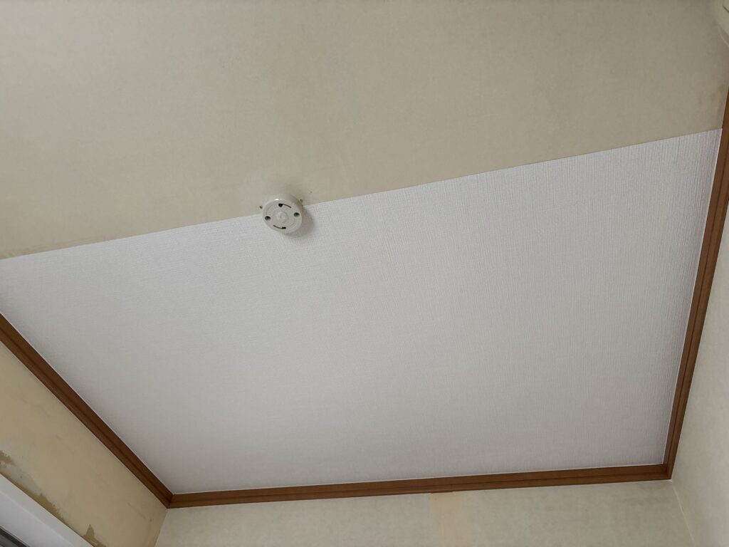 Half of the washroom ceiling covered with new wallpaper