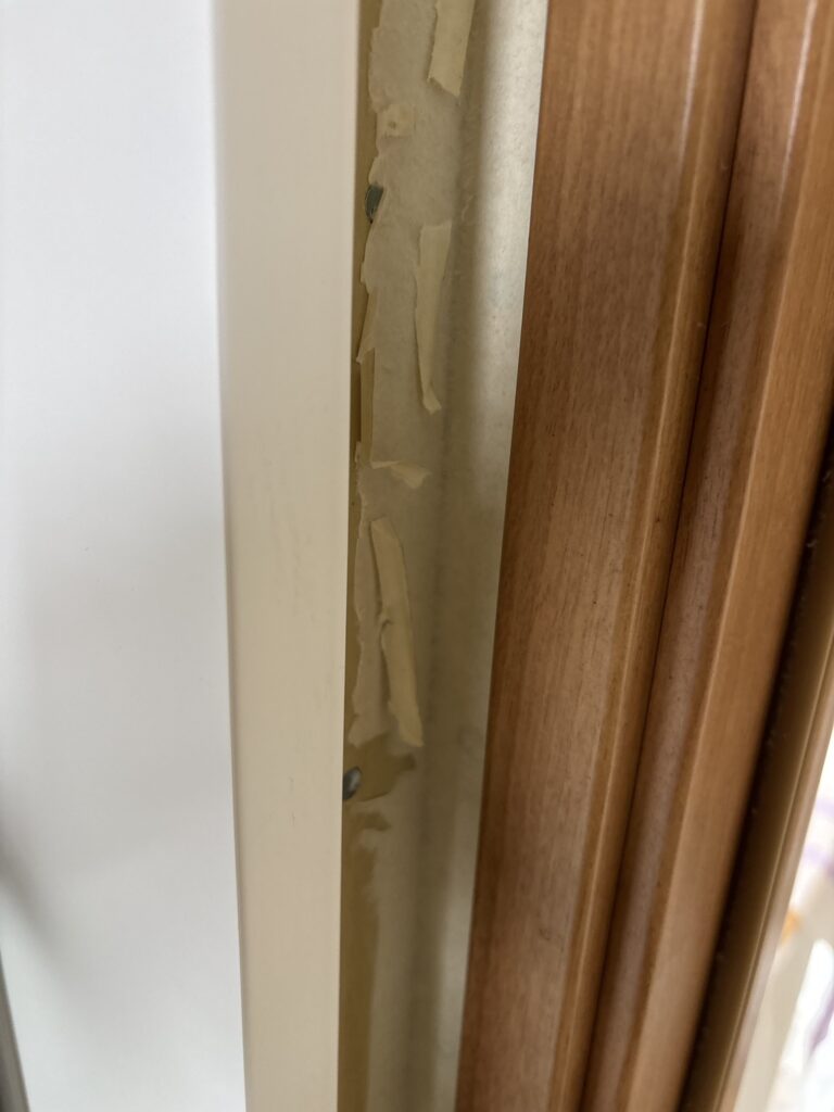 Loose wallpaper backing paper between the bathroom and washroom door frames